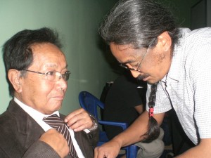 Singer Amrit Gurung fixes a tie on his guru, Ambar Dai, before the Nepalganj concert. PHOTO: KUNDA DIXIT