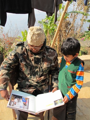 Gyanendra’s father and son Aswin look at the story about him in the book, People After War.