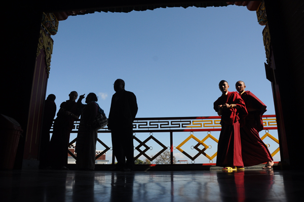 Tourists and monks enter Thrangu Tashi Yangtse Monastery