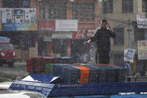 The Kalanki bus station stays busy despite sudden rain on Tuesday evening 