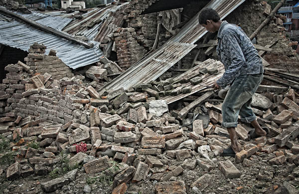  Returning home: a boy searches through the remains and rubble of his house in Hatigauda (1 July)