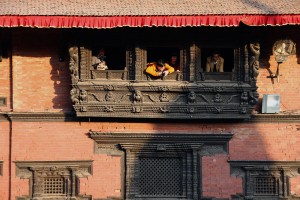 Tourists take photographs and videos of the flash mob from the Patan Museum.