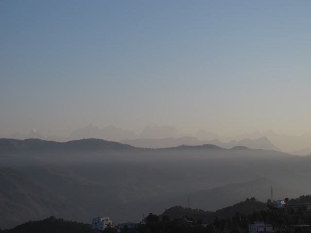 Sunrise in Dadeldhura reveals layers of hills shaded by morning mist and hazy outline of the Api-Saipal range in Humla to the north. 