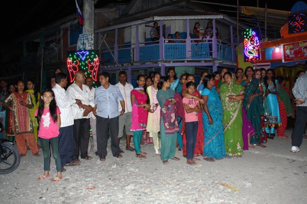 Villagers stand by the roadside outside their houses as the wedding procession approach. They don't want to miss any detail.