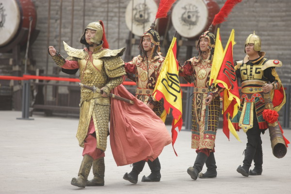 ctors dressed in ancient army armour reenact for tourists at the Xi’an City wall area.