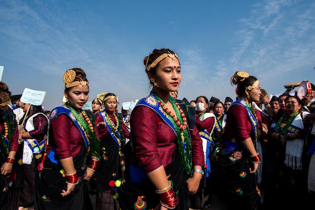 Girls dance in parade, dressed in traditional Gurung cholo and lungi.