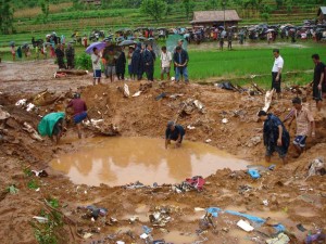 Rescue workers search for remains of the crash as the villagers look on.