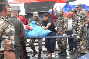 The remains of the Dornier 228 aircraft and the victims of the crash being unloaded and transported to a van.