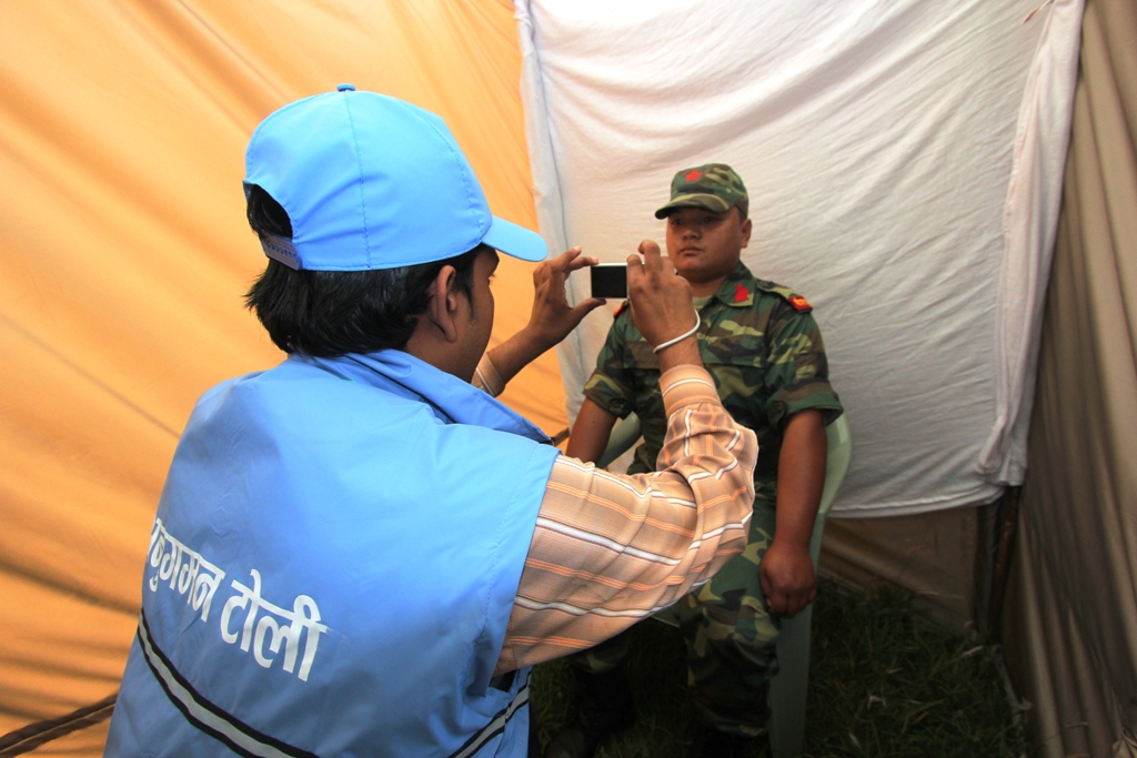 Member of the regrouping team takes picture of an ex-combatant.