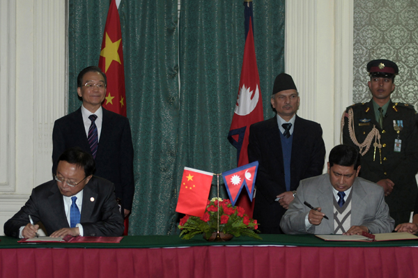 Chinese Premier Wen Jiabao (standing left) and Nepalese Prime Minister Baburam Bhattarai (on second right) watch as the officials from their respective countries sign agreements in Kathmandu on 14th January. 2012. China has agreed to provide $750 million to boost economic ties with Nepal. It says the agreement was signed by the two sides under which Beijing will provide economic and technical assistance to strengthen the country's police and the armed police force.