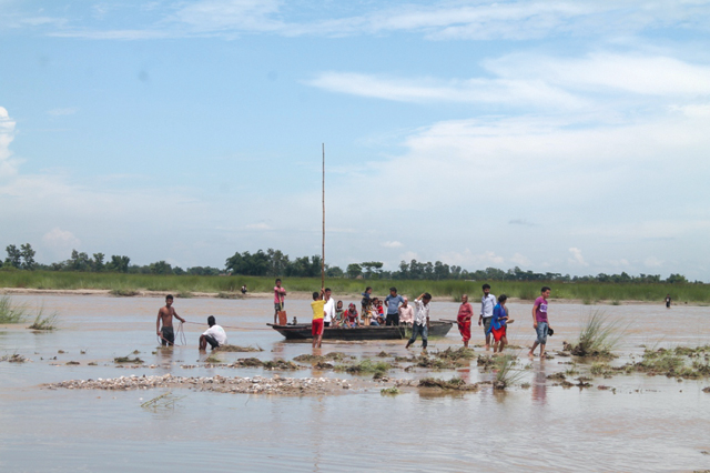 FLOOD OF VOTERS: Swimming, wading or ferried by boats, the residents of Shivasatasi Municipality in Jhapa cross a channel on the Kankai River to vote in the second phase of local elections on Wednesday. Pic: Gopal Gartaula